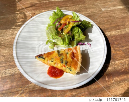 お洒落カフェのカジュアルなコース料理シーフードが入ったキッシュとサラダ 123701743
