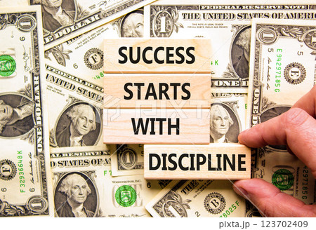 Success starts with discipline symbol. Concept words Success starts with discipline on beautiful wooden blocks. Beautiful dollar background. Business success starts with discipline concept. Copy space Success starts with discipline symbol. Concept words Success starts with discipline on beautiful wooden blocks. Beautiful dollar background. Business success starts with discipline concept. Copy space 123702409