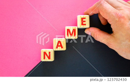 Name symbol. Concept word Name on beautiful wooden blocks. Businessman hand. Beautiful black and purple background. Business, lifestyle, support and name concept. Copy space. 123702430