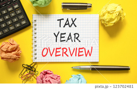 Tax year overview symbol. Concept words Tax year overview on beautiful white note. Beautiful yellow background. Black pen. Black calculator. Business tax year overview concept. Copy space. Tax year overview symbol. Concept words Tax year overview on beautiful white note. Beautiful yellow background. Black pen. Black calculator. Business tax year overview concept. Copy space. 123702481
