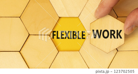 Flexible work symbol. Concept words Flexible work on beautiful wooden puzzles. Beautiful yellow background. Businessman hand. Business Flexible work concept. Copy space. Flexible work symbol. Concept words Flexible work on beautiful wooden puzzles. Beautiful yellow background. Businessman hand. Business Flexible work concept. Copy space. 123702505