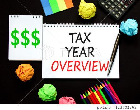 Tax year overview symbol. Concept words Tax year overview on beautiful white note. Beautiful black background. Black pen. Black calculator. Business tax year overview concept. Copy space. Tax year overview symbol. Concept words Tax year overview on beautiful white note. Beautiful black background. Black pen. Black calculator. Business tax year overview concept. Copy space. 123702565