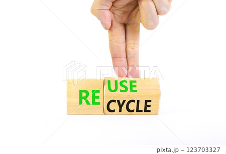 Reuse or recycle symbol. Concept words Reuse Recycle on wooden block. Beautiful white table white background. Businessman hand. Business reuse or recycle concept. Copy space. Reuse or recycle symbol. Concept words Reuse Recycle on wooden block. Beautiful white table white background. Businessman hand. Business reuse or recycle concept. Copy space. 123703327