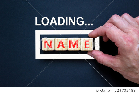 Name symbol. Concept word Loading Name on beautiful wooden blocks. Businessman hand. Beautiful black table black background. Business, lifestyle, support and name concept. Copy space. 123703488