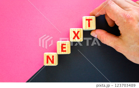 Next symbol. Concept word Next on beautiful wooden blocks. Businessman hand. Beautiful black and purple background. Business, lifestyle, support and next concept. Copy space. 123703489