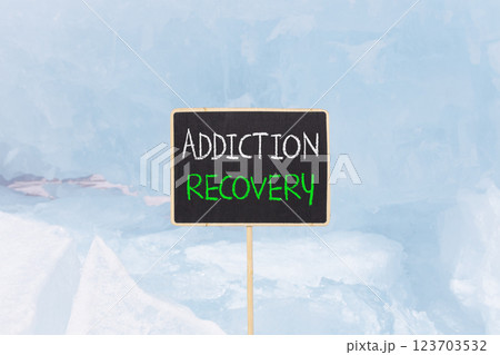 Addiction recovery symbol. Concept words Addiction recovery on beautiful black yellow blackboard. Beautiful blue ice background. Psychology addiction recovery concept. Copy space. Addiction recovery symbol. Concept words Addiction recovery on beautiful black yellow blackboard. Beautiful blue ice background. Psychology addiction recovery concept. Copy space. 123703532