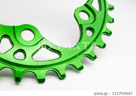 Close up of a green oval bicycle chainring against white isolated background. Professional bicycle part. 123703687