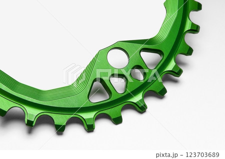 Close up of a green oval bicycle chainring against white isolated background. Professional bicycle part. 123703689
