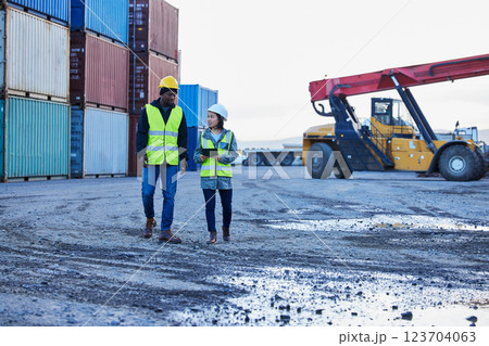 Tablet, container and engineer teamwork planning for manufacturing, shipping and cargo distribution company. Man and woman freight managers talk on stock logistics or delivery 5g tech audit checklist 123704063