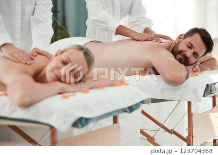 Wellness, massage and relax with a couple in a spa for romance, rest or relaxation on a bed together. Luxury, beauty and love with a man and woman lying in a health club for stress relief or calm 123704368