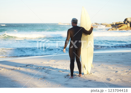 Surf, sport and sea with a man on the beach for fitness, exercise or workout during summer. Surfboard, training and health with a male surfer looking at the sea or ocean view while enjoying a holiday Surf, sport and sea with a man on the beach for fitness, exercise or workout during summer. Surfboard, training and health with a male surfer looking at the sea or ocean view while enjoying a holiday 123704418