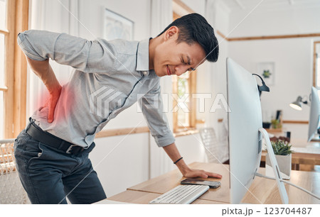 Businessman with back pain, muscle injury and burnout at office desk. Young frustrated man suffering from spinal inflammation, body discomfort or strain and healthcare stress emergency 123704487