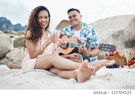 Couple, beach and guitar for music and love on picnic together on sand by ocean. Man, woman and smile with happiness on face with food, champagne and flowers to relax, vacation and travel in summer 123704525
