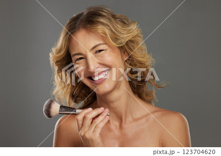 Makeup, skincare and woman with cosmetics brush for her daily facial beauty and wellness routine in studio. Smile, senior and happy person applying foundation products in portrait with mockup space Makeup, skincare and woman with cosmetics brush for her daily facial beauty and wellness routine in studio. Smile, senior and happy person applying foundation products in portrait with mockup space 123704620