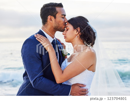 Wedding, hug and couple kiss by beach for commitment, care or bonding together. Sea, travel and man with woman for love embracing at romantic, tropical and destination marriage ceremony by ocean. Wedding, hug and couple kiss by beach for commitment, care or bonding together. Sea, travel and man with woman for love embracing at romantic, tropical and destination marriage ceremony by ocean. 123704801