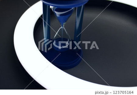 Falling Sand In Blue Hourglass Inside A Ring Of Light Isolated Stock Photo Falling Sand In Blue Hourglass Inside A Ring Of Light Isolated Stock Photo 123705164