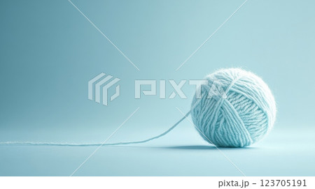 Light blue yarn ball unrolling on seamless background 123705191