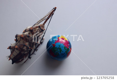 Blank for cards and backgrounds with a globe and a model of an old frigate on a white surface Blank for cards and backgrounds with a globe and a model of an old frigate on a white surface 123705258