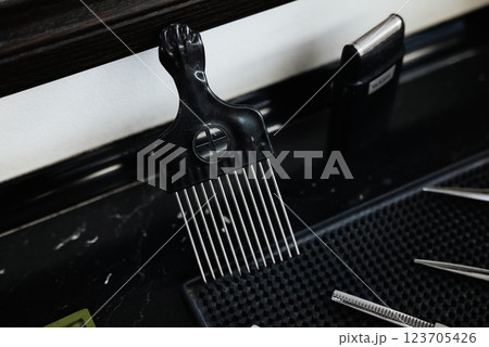 Black comb and grooming tools on a barber shop counter 123705426