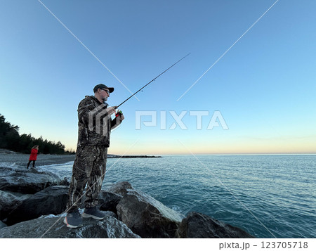 Young happy woman and old man is fishing at sea during spring vacation 123705718