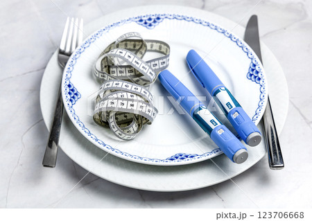 Ozempic Insulin injection pen or insulin cartridge pen for diabetics on a white plate. 123706668