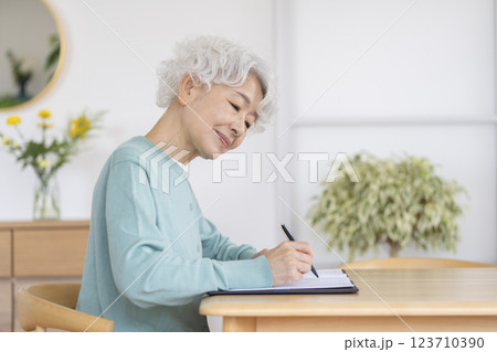 ペンを持って書き物をするシニア女性の横顔 123710390