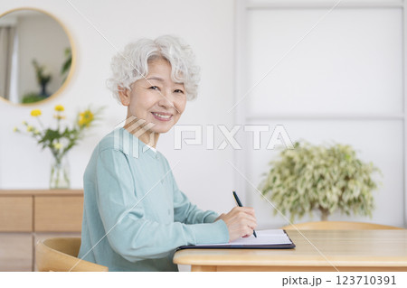 ペンを持った笑顔のシニア女性 カメラ目線 ペンを持った笑顔のシニア女性 カメラ目線 123710391