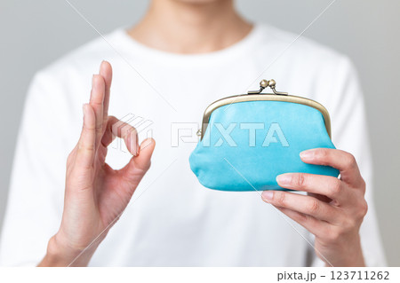 黄色のがま口財布を持って丸サインをするミドル女性 123711262