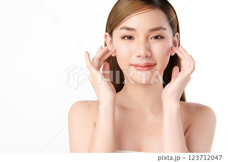 A beautiful young Asian woman with clean, fresh skin against a white background. She represents beauty, skincare, and spa treatments. 123712047