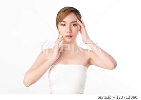 A beautiful young Asian woman with clean, fresh skin against a white background. She represents beauty, skincare, and spa treatments. 123712060