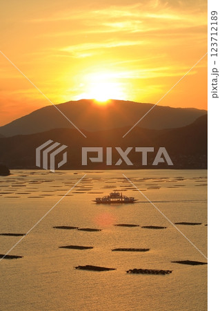 夕暮れ時の瀬戸内海を ゆっくり進むフェリー 123712189