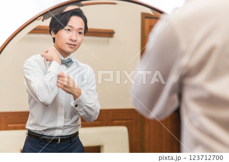 控え室・ブライズルームで結婚式・挙式・披露宴の準備をする新郎・花婿(カフスボタン) 控え室・ブライズルームで結婚式・挙式・披露宴の準備をする新郎・花婿(カフスボタン) 123712700