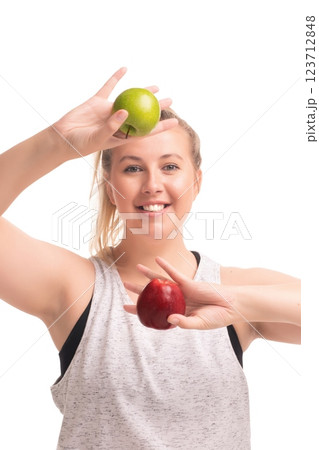 Smiling woman holds green and red apples in a bright studio setting 123712848