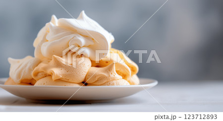 Meringue cookies with whipped topping on white plate, soft and airy texture 123712893