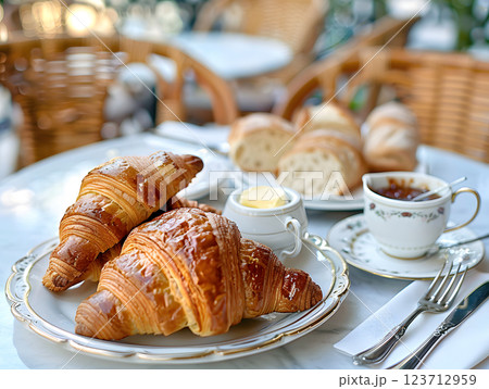 french breakfast with croissants, coffee, and fresh bread on an outdoor table 123712959