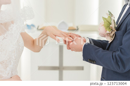 結婚式場で指輪交換する新郎新婦(結婚式・ウェディング・ブライダル) 結婚式場で指輪交換する新郎新婦(結婚式・ウェディング・ブライダル) 123713004