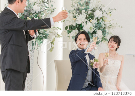 結婚式で乾杯の挨拶をする男性と新郎新婦 123713370