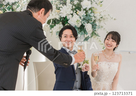 結婚式で乾杯の挨拶をする男性と新郎新婦 123713371