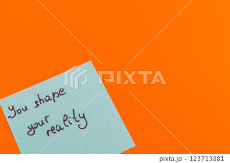 Handwritten motivational note on a vibrant orange background 123713881
