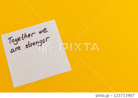 Message of unity on a bright yellow background with handwritten text Message of unity on a bright yellow background with handwritten text 123713907
