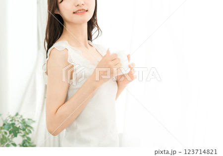 朝、家で白湯・コーヒー・ホットドリンク・カフェオレ・カフェラテを飲む笑顔のアジア人女性 朝、家で白湯・コーヒー・ホットドリンク・カフェオレ・カフェラテを飲む笑顔のアジア人女性 123714821