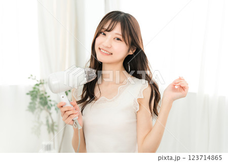 ヘアドライヤーでヘアブロー・髪の毛を乾かす女性（ヘアケア） 123714865
