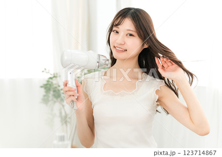 ヘアドライヤーでヘアブロー・髪の毛を乾かす女性（ヘアケア） 123714867