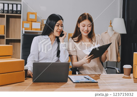 Startup SME small business entrepreneur of freelance Asian woman using a laptop with box Cheerful success Asian woman her hand lifts up online marketing packaging box and delivery SME idea concept 123715032