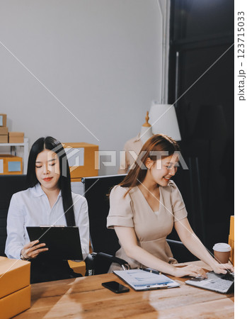 Startup SME small business entrepreneur of freelance Asian woman using a laptop with box Cheerful success Asian woman her hand lifts up online marketing packaging box and delivery SME idea concept 123715033