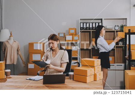 Startup SME small business entrepreneur of freelance Asian woman using a laptop with box Cheerful success Asian woman her hand lifts up online marketing packaging box and delivery SME idea concept Startup SME small business entrepreneur of freelance Asian woman using a laptop with box Cheerful success Asian woman her hand lifts up online marketing packaging box and delivery SME idea concept 123715041