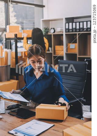 Asian SME business women use laptop computer checking customer order online shipping boxes at home. Starting Small business entrepreneur SME freelance. Online business, Work at home concept. 123715069