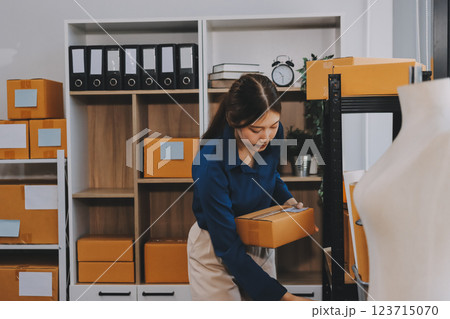 Asian SME business women use laptop computer checking customer order online shipping boxes at home. Starting Small business entrepreneur SME freelance. Online business, Work at home concept. Asian SME business women use laptop computer checking customer order online shipping boxes at home. Starting Small business entrepreneur SME freelance. Online business, Work at home concept. 123715070