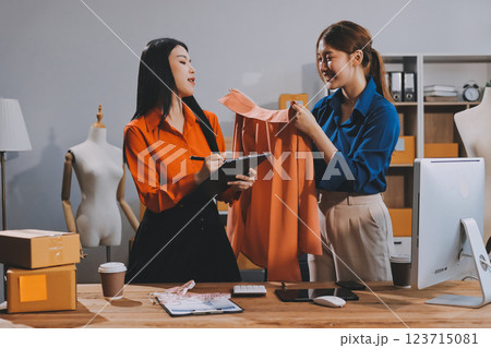 Fashion blogger concept, Young Asian women selling clothes on video streaming.Startup small business SME, using smartphone or tablet taking receive and checking in office 123715081