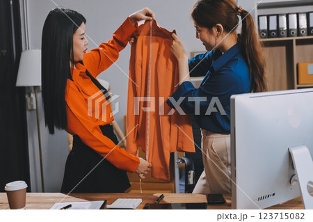 Fashion blogger concept, Young Asian women selling clothes on video streaming.Startup small business SME, using smartphone or tablet taking receive and checking in office 123715082